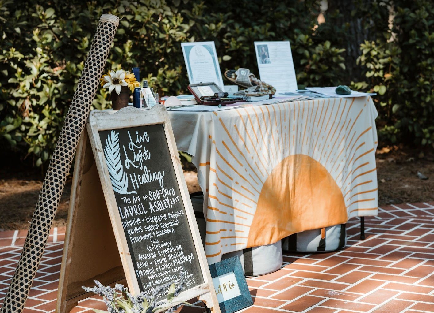 Live Light Healing event table with sun print linen, crystals, and intake cards