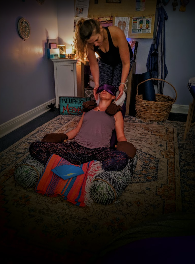 Laurel placing hands at a client's crown during an energy session